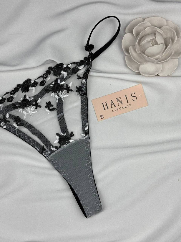 نمای بسته و کلوزآپ از شورت بکلس توری گلدار مشکی با مارک Hanis Lingerie در کنار گل تزیینی